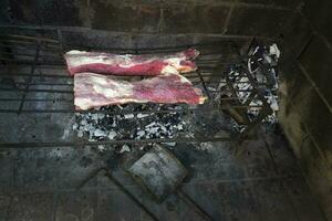 crudo carne poner en el parrilla, tradicional argentino cocina, asado parilla, Patagonia, argentina. foto