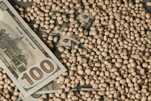 Dollars banknotes and coins and soy beans, commoditi value concept. photo