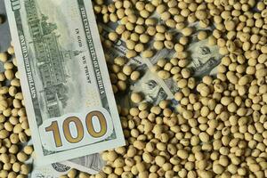 Dollars banknotes and coins and soy beans,oleaginous commoditi value concept. photo