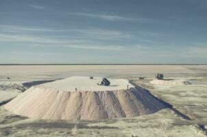 Trucks unloading raw salt bulk, Salinas Grandes de Hidalgo, La Pampa, Argentina. photo