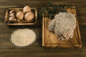 Veal milanese presented on the table with ingredients photo