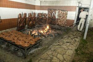 Gaucho roast barbecue, sausage and cow ribs, traditional argentine cuisine, Patagonia, Argentina. photo