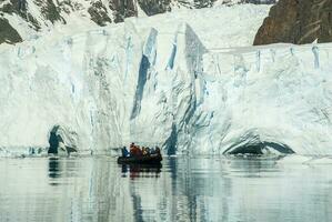 Tourists watching a glacier in Antarctica, near the Antarctic Peninsula. photo