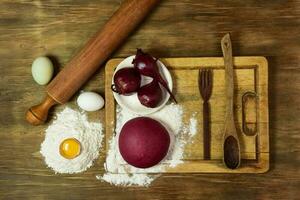 púrpura masa bollo para tallarines con ingredientes en el mesa. foto