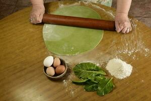 de la abuela manos amasadura, masa para verde fideos. foto