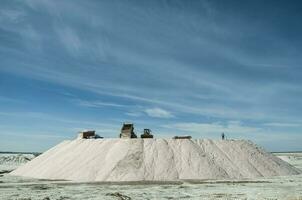 Trucks unloading raw salt bulk, Salinas Grandes de Hidalgo, La Pampa, Argentina. photo