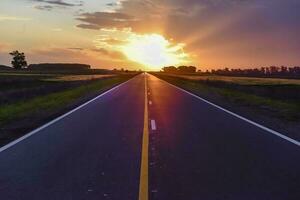 Landscape with road and stormy sky at sunset photo