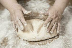 Hands kneading dough for gnocchi. photo