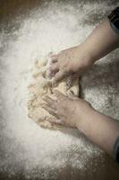 Hands kneading dough for gnocchi. photo