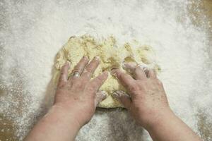 Hands kneading dough for gnocchi. photo