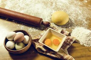 Yellow dough with ingredients on the table, homemade italian food. photo