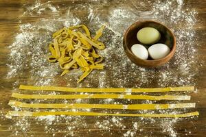 Yellow dough with ingredients on the table, homemade italian food. photo