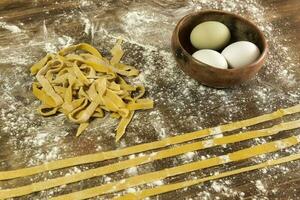 Yellow dough with ingredients on the table, homemade italian food. photo