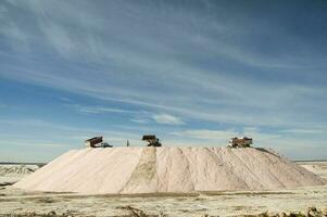 Trucks unloading raw salt bulk, Salinas Grandes de Hidalgo, La Pampa, Argentina. photo