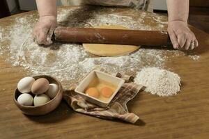 Egg dough for noodles, with ingredients on the table, traditional italian cuisine. photo