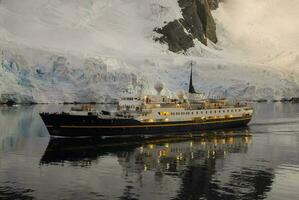 Expedition ship, cruise in Antarctic landscape, Lemaire Strait, Antarctic Peninsula photo