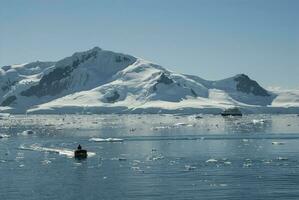 Tourists observing a glacier on the Antarctica, Paradise bay, Antartic Peninsula. photo