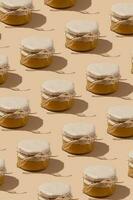 modelo desde vaso tarro con miel debajo Kraft papel en un cuerda en beige antecedentes. dulce comida monocromo concepto. foto