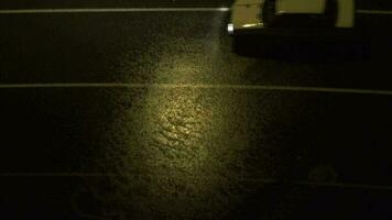 ondas do pesado chuva água em asfalto estrada às noite debaixo amarelo rua luzes video