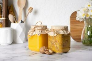 Jars with honey and walnuts. Walnuts in honey in the kitchen interior photo