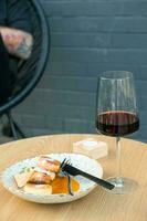 A glass of wine with cheesecakes on plate on a wooden table photo