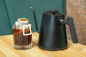 Drip coffee in a glass cup on a wooden table in the interior of a cafe photo