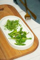 Microgreens sunflower and alfalfa with cutlery on the table. photo