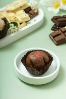 Craft chocolate candy in small plate. Healthy sweet food still life photo