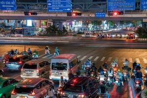 Ho Chi Minh, Viet Nam - 24 April 2023 Vietnamese crowned people with rush hour in heavy rain and traffic jam photo