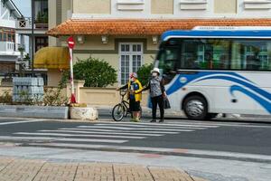 da lat, viet nam - 3 junio 2023 abuela Guías su nieto a el la carretera marcas foto