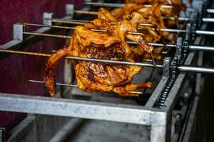 Close-up of roasting a whole chicken in a simple grill in Asia photo