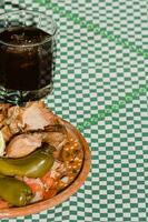 el mexicano Carnitas, un delicioso alimento, es servido con varios condimentos en un mesa con vajilla foto
