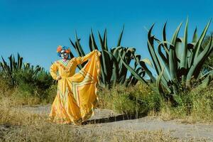 mexicano mujer en vistoso vestir y cráneo maquillaje en el mexicano Desierto cactus foto