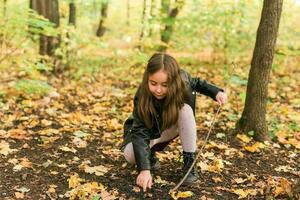 asiático niño niña jugando en otoño en naturaleza. infancia y temporada concepto. foto