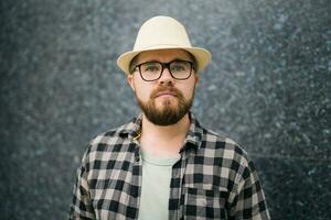 Handsome sad guy tourist wearing straw hat for travelling, standing against concrete wall background photo