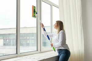 Washing window with special mop and cleaning services - housework and housewife concept photo