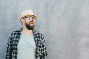 Handsome guy tourist looking happy wearing straw hat for travelling, standing against concrete wall background with copy space photo