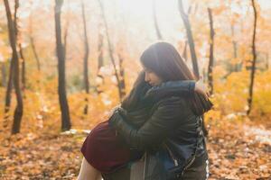 Mother and daughter spend time together in autumn yellow park. Season and single parent concept. photo