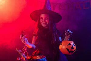 Little witch child cooking potion in the cauldron on Halloween. photo