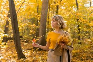 retrato de hermosa joven mujer caminando al aire libre en otoño. otoño temporada y elegante niña concepto. foto