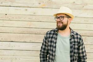 Happy man wearing hat over wooden background with copy space - vacation travel holidays concept photo