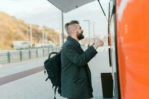 Portrait of man choosing fast food in food truck in the street. Meal, food industry and streetfood concept. photo