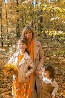 Beautiful lifestyle autumn photo mother and child walks evening in the park, warm sunlight.