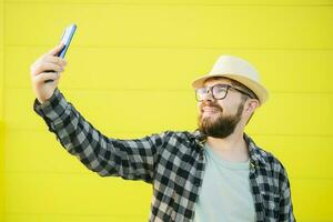 Man telling something at the camera while traveling at new city, yellow street wall background. Blogger and vlog concept photo