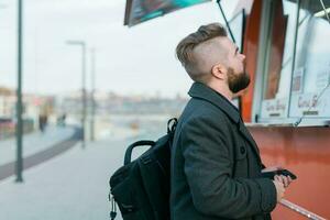 Portrait of man choosing fast food in food truck in the street. Meal, food industry and streetfood concept. photo