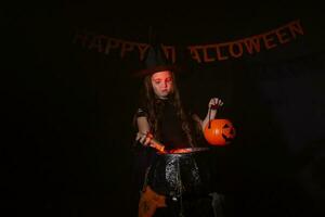 Little witch child cooking potion in the cauldron on Halloween. photo