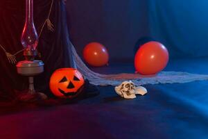 Symbol of Halloween. Jack-o-lantern on a dark background and artificial skull. Halloween card. Lamp in decorations. Background. photo