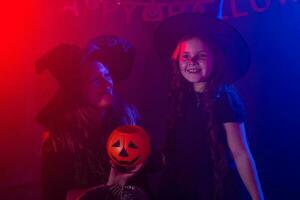 Funny child girl and woman in witches costumes for Halloween. photo