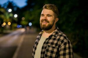 retrato de hombre en pie en noche ciudad calle con Copiar espacio y sitio para texto. confidente contento chico. de cerca retrato foto