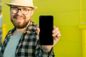 Hot offering. Happy guy holds cellphone with black copy space and smiling. Human emotions facial and place for advertising and text photo